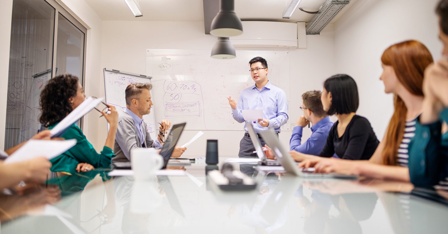 Image of a employee addressing other colleague in a meeting.